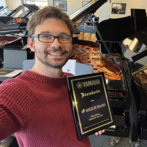 Chris Neiner with Yamaha National Dealer of the Year Award at Solich Piano Cleveland