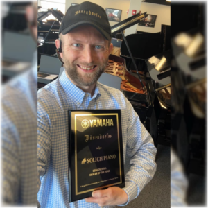 Kyle Merritt with Yamaha National Dealer of the Year Award at Solich Piano Cleveland